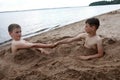Two children play on sandy beach of Lake Seliger Royalty Free Stock Photo