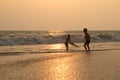 Two children is playing on the beach in sunset