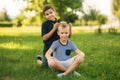 Two children are playing in the park. Two beautiful boys in T-shirts and shorts have fun smiling. They eat ice cream Royalty Free Stock Photo