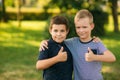 Two children are playing in the park. Two beautiful boys in T-shirts and shorts have fun smiling. They eat ice cream Royalty Free Stock Photo