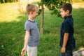 Two children are playing in the park. Two beautiful boys in T-shirts and shorts have fun smiling. They eat ice cream Royalty Free Stock Photo