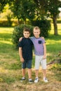 Two children are playing in the park. Two beautiful boys in T-shirts and shorts have fun smiling. They eat ice cream Royalty Free Stock Photo