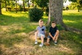 Two children are playing in the park. Two beautiful boys in T-shirts and shorts have fun smiling. They eat ice cream Royalty Free Stock Photo