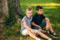 Two children are playing in the park. Two beautiful boys in T-shirts and shorts have fun smiling. They eat ice cream Royalty Free Stock Photo