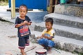 Two children playing sand cooking on the village road Royalty Free Stock Photo