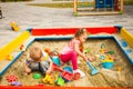 Two children playing in sandbox in sunny day Royalty Free Stock Photo