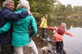 Two children playing at the shore of a lake, their grandparents in the foreground, Lake District, UK