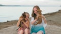 Two children playing which dogs on the sand on the beach. Royalty Free Stock Photo