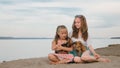 Two children playing which dogs on the sand on the beach. Royalty Free Stock Photo