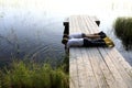 Two children playing on wooden bridge by lake Royalty Free Stock Photo