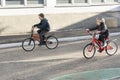 Two children ride bicycles on the paved road. Biking with friend