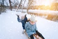 Two children ride on wooden retro sled on sunny winter day. Active winter outdoors games. Winter activities for kids Royalty Free Stock Photo