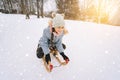 Two children ride on wooden retro sled on sunny winter day. Active winter outdoors games. Winter activities for kids Royalty Free Stock Photo