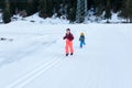 Two children running in the snow valley against forest and mountain background Royalty Free Stock Photo