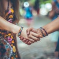 Two girls shaking hands and wear friendship bracelets