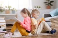 Two children sitting on the floor in the room and reading books Royalty Free Stock Photo