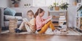 Two children sitting on the floor in the room and reading books. Royalty Free Stock Photo