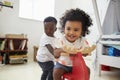 Two Children Sitting On Ride On Toy In Playroom Royalty Free Stock Photo