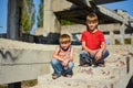 Two children are sitting on the steps of an abandoned building, a concept of the life of street children orphans