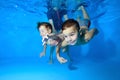 Two children, a small boy and a girl, are engaged in swimming in a children`s pool. They play and dive under the water Royalty Free Stock Photo