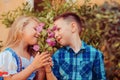 Two children smell the flowers green tree background. Boy brother gives a flower to the girl sister. Love care concept Royalty Free Stock Photo