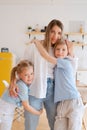 Two children son and daughter hug their mother. Happy loving family standing Royalty Free Stock Photo