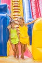 Two children stand at entrance of a large inflatable trampoline