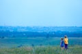 Two children in the summer stand in a field on a hill and look into the distance. Future vision concept. Walks in the open air. Royalty Free Stock Photo