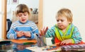 Two children together with pencils