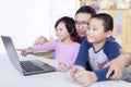 Two children using laptop with teacher in class Royalty Free Stock Photo