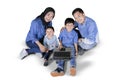 Two children using a laptop with their parents Royalty Free Stock Photo