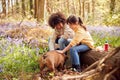 Two Children Walking Pet Dog Through Bluebell Woods In Springtime Taking A Break Sitting On Log Royalty Free Stock Photo