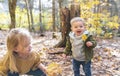 Two children on wood on the autumn season