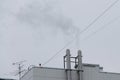 From two chimneys on the roof of the house comes smoke against the sky Royalty Free Stock Photo