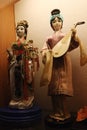 Two chinese decorative figures of women, female musician holding Pipa and second one, possibly dancer or actor, holding decorative