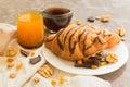 Two chocolate croissants raisins, nuts, a cup of coffee and a glass of orange juice on a gray background. Close-up. Breakfast conc Royalty Free Stock Photo