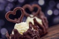 Two chocolate desserts filled with white cream on wooden table, dessert with chocolate hearts for valentines or wedding day Royalty Free Stock Photo