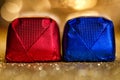 Blue and red foil wrapped chocolates on gold glitter background. Royalty Free Stock Photo