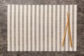 Two chopsticks and bamboo mat on cement background. Top view, copy space Royalty Free Stock Photo