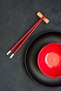 Two chopsticks next to  black and red bowl. Asian style Royalty Free Stock Photo