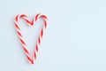 Two Christmas candy cane caramel in the shape of heart on white background Royalty Free Stock Photo