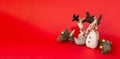 Two Christmas deer, branches of spruce and Christmas balls on a red background. Christmas background, horizontal Royalty Free Stock Photo