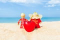 Two Christmas doll an angel give a Heart on the sand beach and b