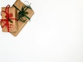 Two Christmas gift boxes packed in kraft and red and green ribbons on a white background