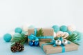 Christmas gift boxes wrapped of craft paper, blue and white ribbons, decorated of fir branches, Christmas balls and pine cones. Royalty Free Stock Photo