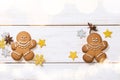 Two Christmas gingerbread men, golden sparkling stars and star anise on white background. Merry Christmas greeting card Royalty Free Stock Photo