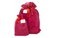 Two Christmas presents wrapped in a burgundy fabric with a ribbon, with the inscription `a gift for you` on a piece of paper, isol