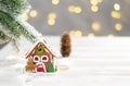 Toy house and christmas tree with fir cones, abstract light white natural holiday background with copy space Royalty Free Stock Photo