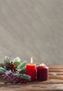 Two christmas red burning candles and branch of christmas tree on the wooden background holiday new year vertical Royalty Free Stock Photo