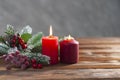 Two christmas red burning candles and branch of christmas tree on the wooden background Winter holiday xmas and new year Royalty Free Stock Photo